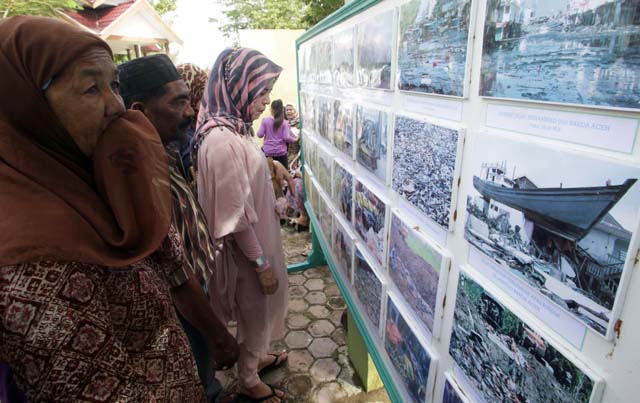 People look at photographs of the 2004 tsunami, at the Ulee Lheue mass grave near Banda Aceh, Aceh province (detik.com)