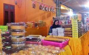 Kak-Peni-sedang-menunggu-pelanggan-untuk-membeli-dagangan-jajanan-khas-Aceh-miliknya-dilintasan-jalan-Meulaboh-Banda-Aceh