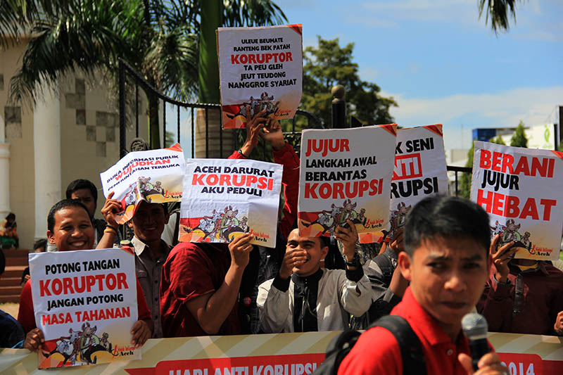 Para aktivis membawa slogan "Uleue Beumate Ranteng Bek Patah Koruptor ta Peugleh Jeut Teudong Nanggroe Syari'at" di Hari Anti Korupsi Internasional (HAKI) di depan Masjid Raya Baiturrahman, Banda Aceh. (Foto M Iqbal/SeputarAceh.com)