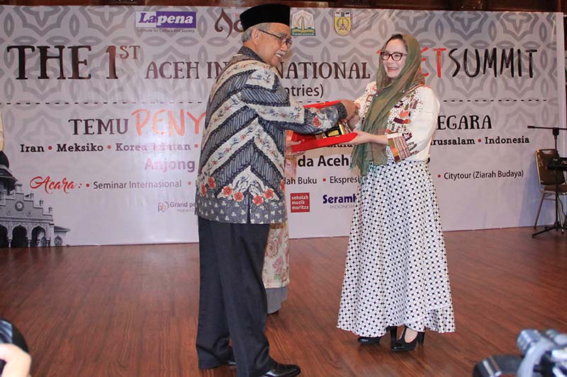 Gubernur Aceh Zaini Abdullah menyerahkan cinderamata kepada Atzimba Becerril (Meksiko) peserta acara Aceh International Poet Summit di Banda Aceh (Foto M Iqbal/SeputarAceh.com)